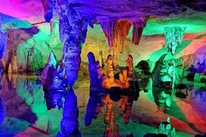 Une grotte ornée de stalactites et de stalagmites aux couleurs vives.