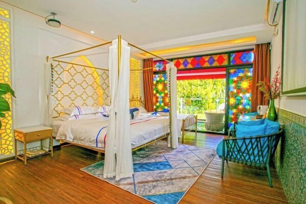 A four-poster bed with a canopy, a small table, a chair, and a view of greenery outside. - 52 Hertz Guesthouse (Shenzhen)