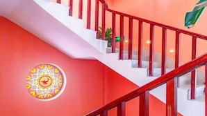 Una escalera con barandas rojas y un adorno circular en la pared.