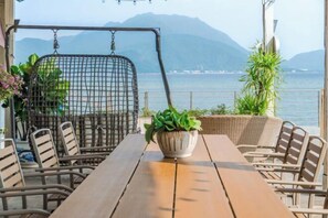 A wooden table with wicker chairs, a hanging swing, and a potted plant. - 52 Hertz Guesthouse (Shenzhen)