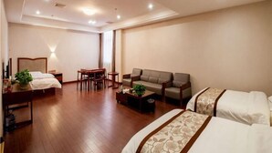 Ein Hotelzimmer mit Bett, Sofa, Couchtisch, Schreibtisch und Stuhl.