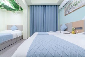 Habitación de hotel con dos camas, un ventanal con cortinas, un aire acondicionado instalado en la pared y un cuadro.