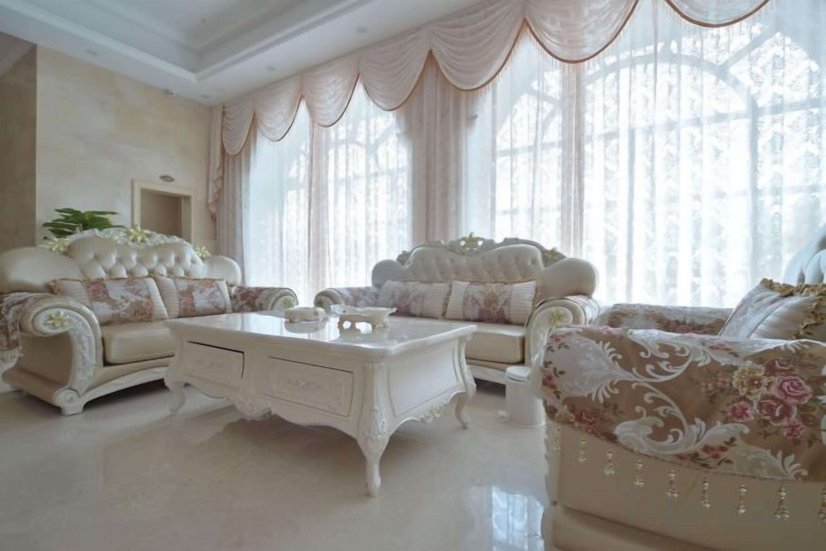 A luxurious living room with ornate furniture, large windows, and a classic design.