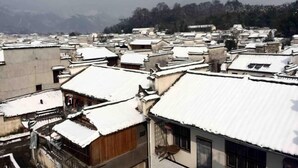 A traditional village with snow-covered rooftops and buildings.