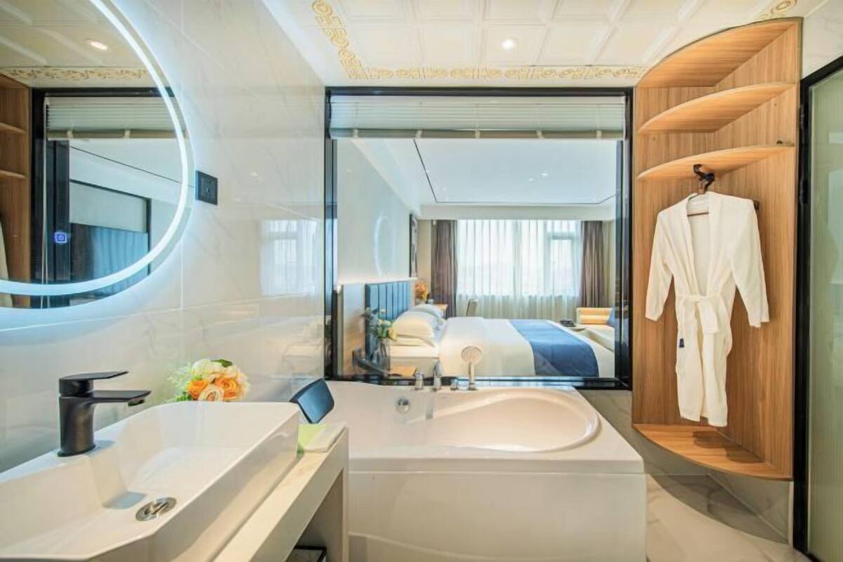 A modern bathroom with a large sink, mirror, and wooden vanity.