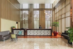 A reception area with a reception desk, seating, and a large window. - Yunshang City Impress Hotel (Wuxi)