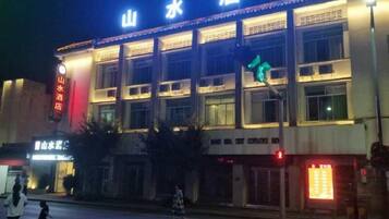 A building with signage indicating it is a hotel, multiple floors, and a visible entrance.