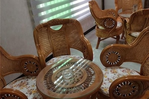A room with wicker furniture, including chairs and a table with a glass top. - " Liuba Landscape Hotel" (Liuba)