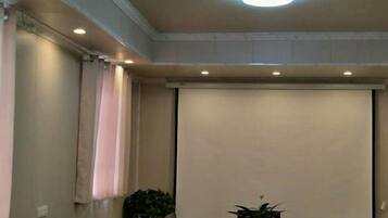A conference room with a projection screen, a table, and chairs.