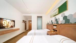Ein Hotelzimmer mit zwei Betten, einem Fernseher, einem hölzernen Kopfteil und einer geometrischen Wanddekoration.
