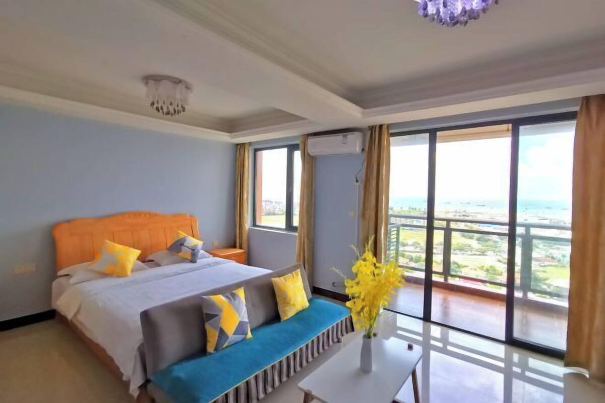 Hotelkamer met een groot bed, een bank, een tafel en uitzicht op de stad.