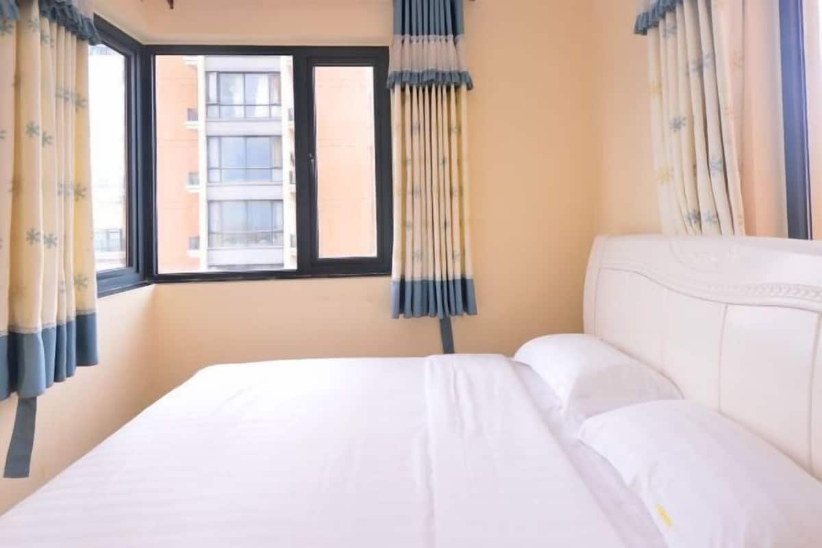 Quarto de hotel com cama, cortinas e janela.
