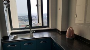 A kitchen with a window, a sink, and a kettle.