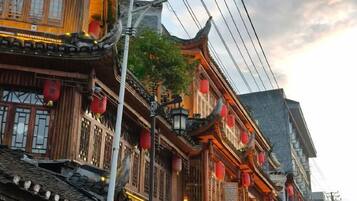 Un edificio tradicional con varios pisos, balcones de madera y faroles rojos.