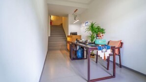 A modern kitchen with a dining area, a staircase, and a potted plant. - Phoenix Ancient City Lingjiang Muyue Riverside Homestay (Fenghuang County)