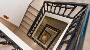 A modern staircase with a black metal railing and a decorative glass panel at the bottom. - Phoenix Ancient City Lingjiang Muyue Riverside Homestay (Fenghuang County)