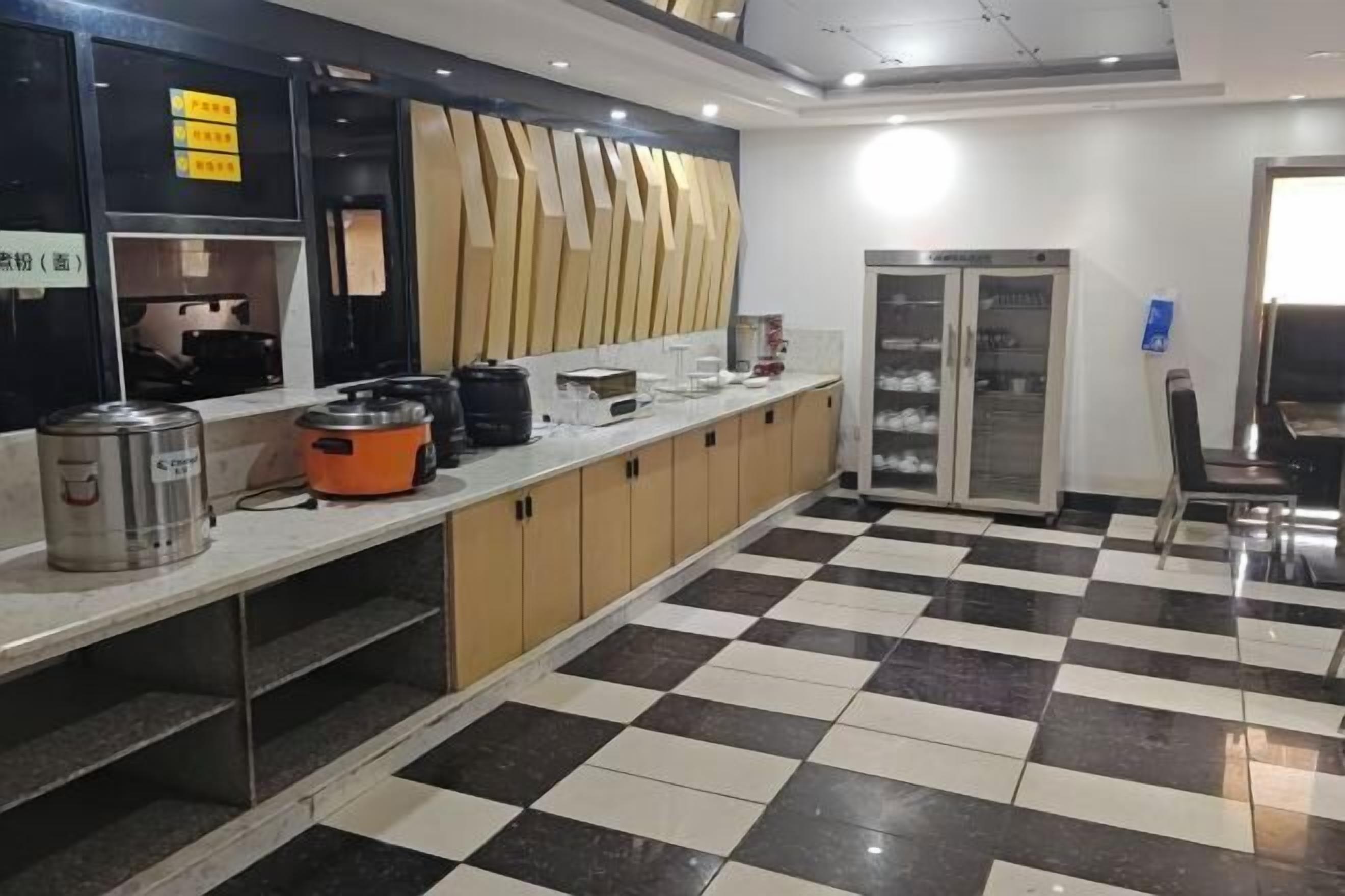 Una cocina con piso a cuadros, un refrigerador y un lavamanos.