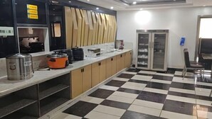 A kitchen with a checkered floor, a refrigerator, and a sink.