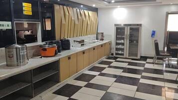 Una cucina con pavimento a scacchi, un frigorifero e un lavello.