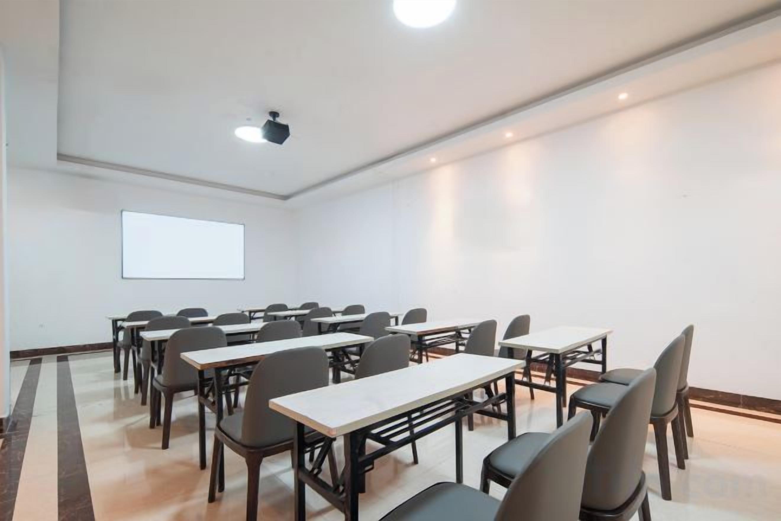 Una sala conferenze con tavoli e sedie disposte per riunioni.