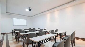 Una sala conferenze con tavoli e sedie disposte per riunioni.