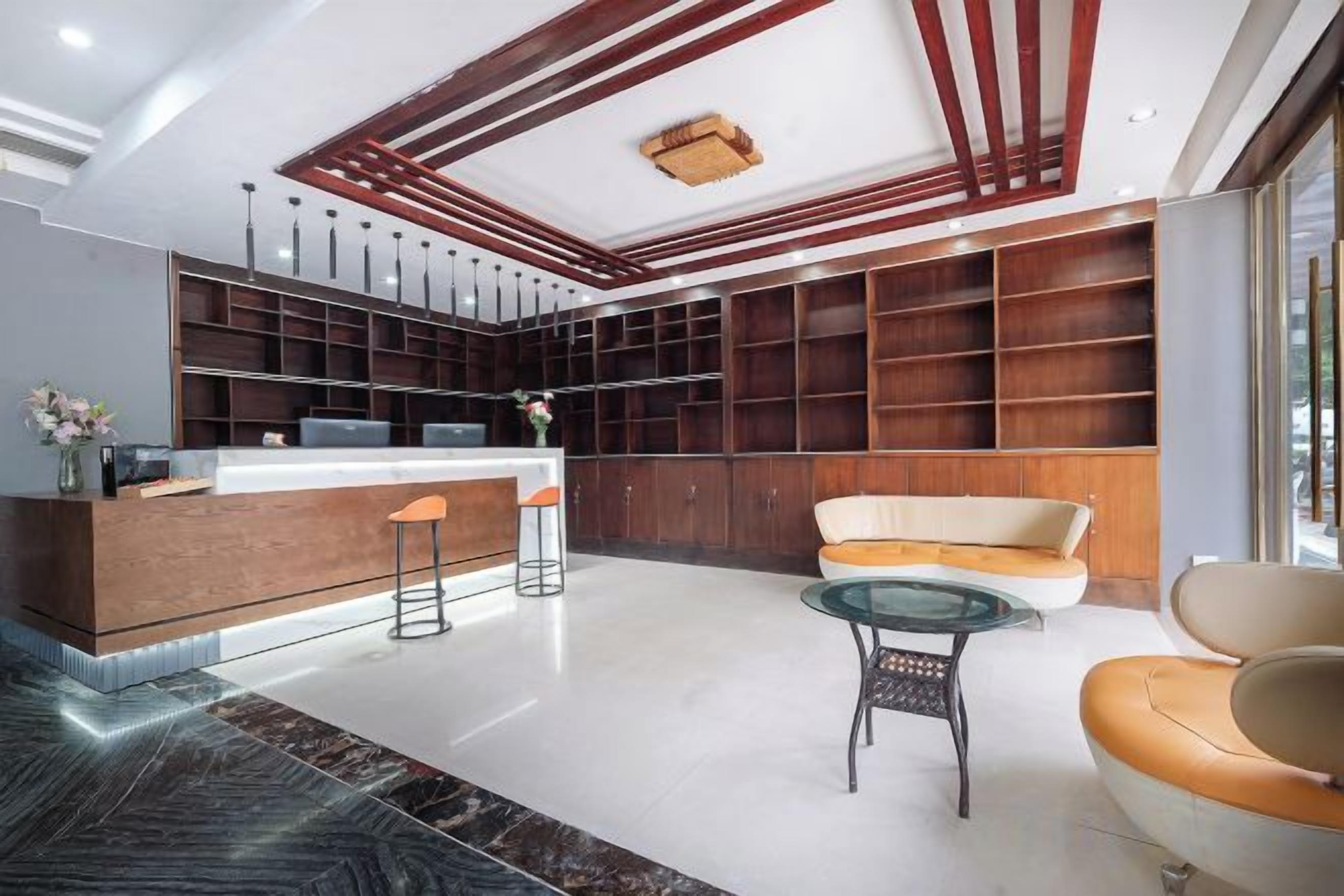 Una hall moderna con reception, area salotto e scaffalature a parete.