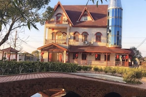 A two-story building with a balcony, a cylindrical tower, and a bridge in the foreground. - Beihu Bay Resort (Shanghai)