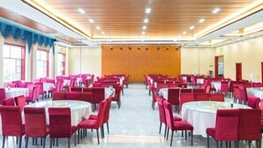 A banquet hall with round tables and red chairs, wooden ceiling, and large windows. - Jingbian Danxia Tourism Resort (Jingbian County)