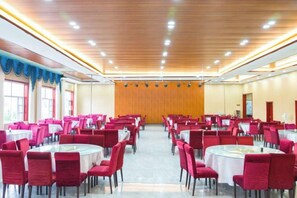 A banquet hall with round tables and red chairs, wooden ceiling, and large windows. - Jingbian Danxia Tourism Resort (Jingbian County)