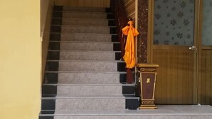A staircase leading to a room with a wooden door and a patterned wall. - Niegan Dawa Hotel (Diebu)