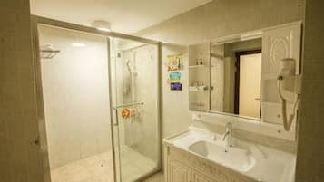 A bathroom with a glass-enclosed shower, a sink with a mirror, and a towel rack.