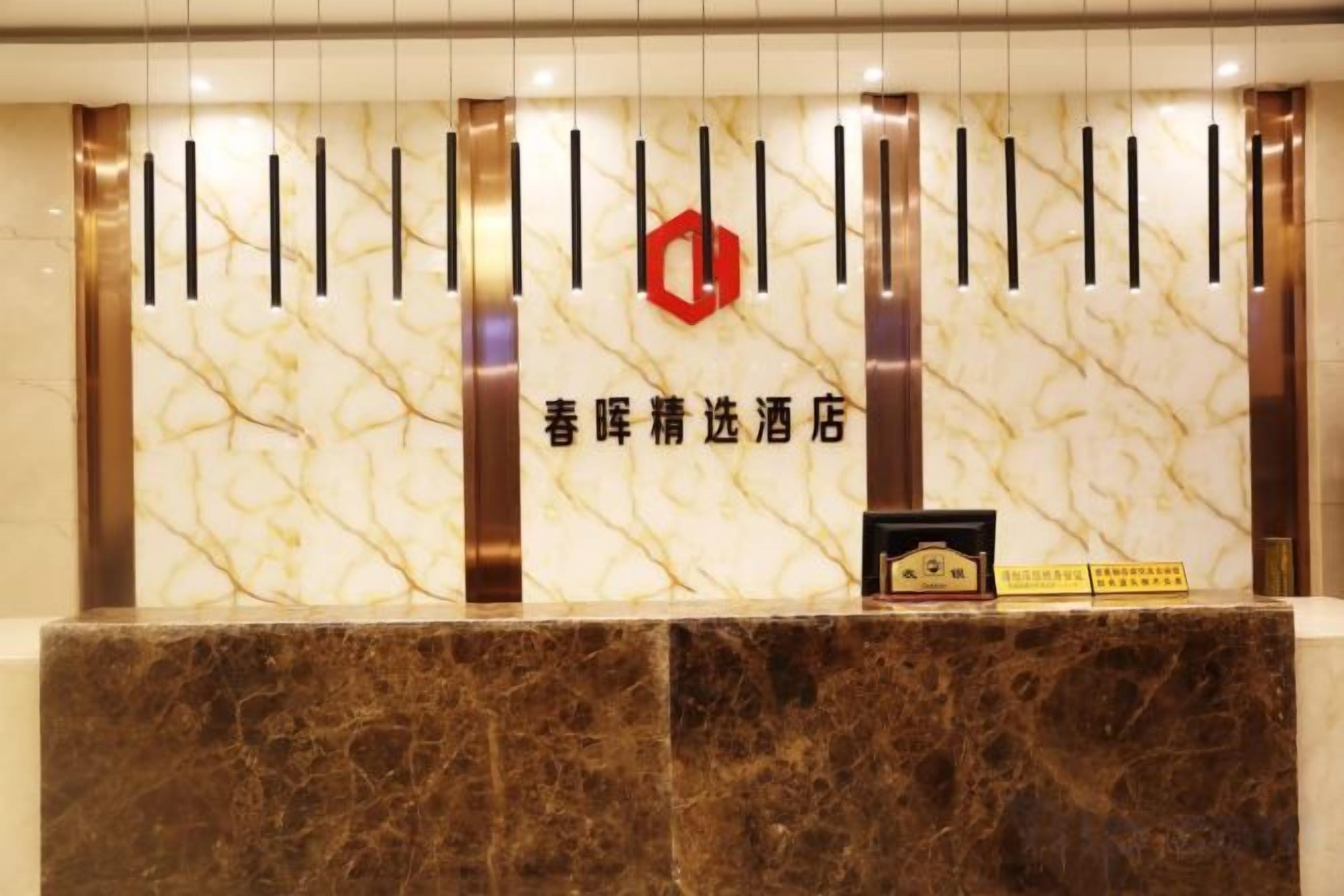 A reception desk with a marble countertop, a red logo, and a black and white sign.