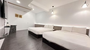 A modern hotel room with two beds, a flat-screen TV, and a small desk with a mirror. - Kenting Hostel（Villa） (Pingtung)