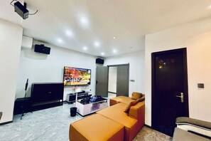 Un salon moderne avec un téléviseur à écran plat, un canapé et une table basse.