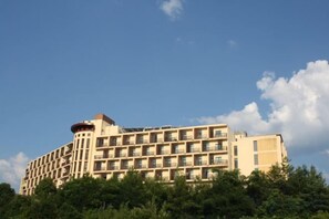 Un hotel de varios pisos con fachada plana, numerosas ventanas y balcones.