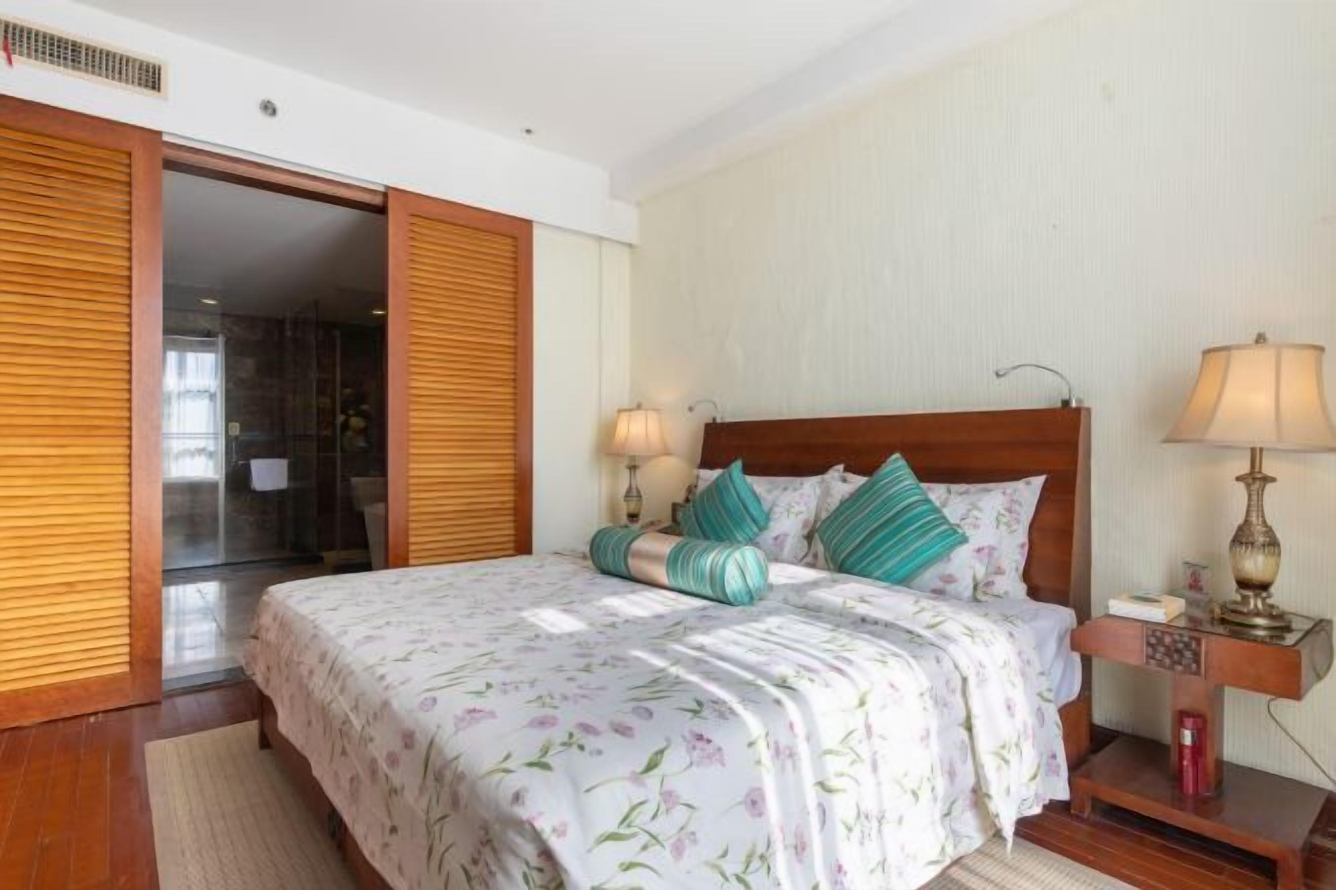 Un dormitorio con cama, mesitas de noche y un armario.