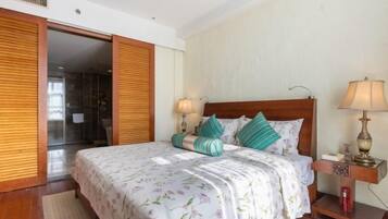 Un dormitorio con cama, mesitas de noche y un armario.