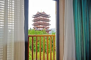 Páteo com grade de madeira emoldura uma pagoda tradicional de vários andares.