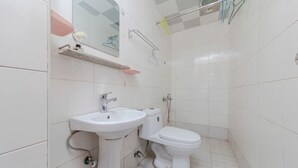 Un baño con lavamanos, inodoro y ducha.