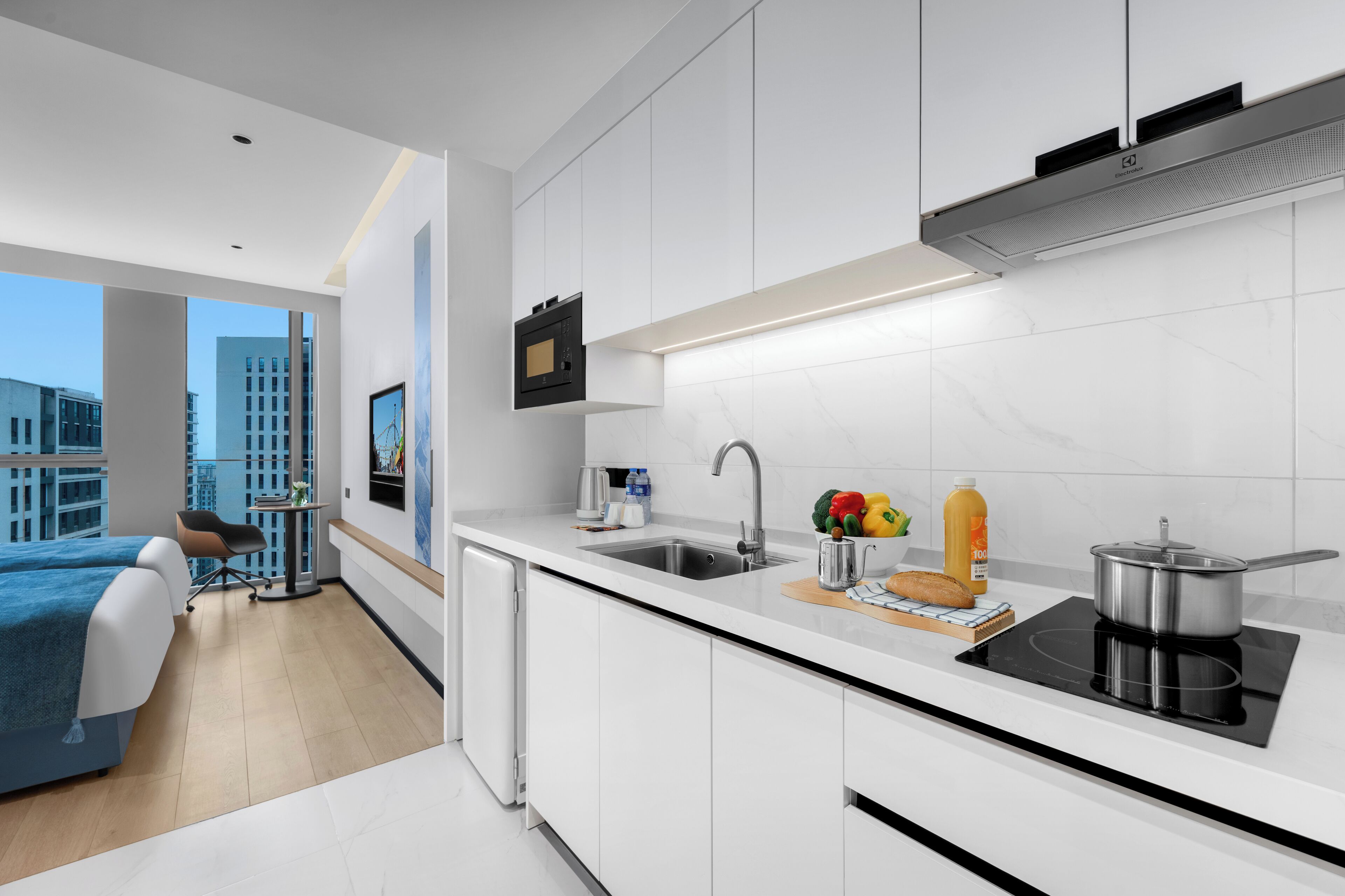 A modern kitchen with white cabinets, a black countertop, and a built-in stove.