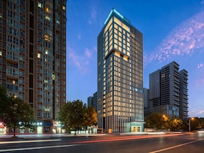 A high-rise building with a modern architectural design, featuring a prominent entrance and a well-lit facade. - Citadines Guanghua Chengdu (Chengdu)