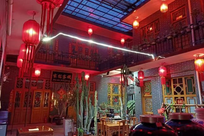 Un interior tradicional con techo alto, faroles rojos y un tragaluz.