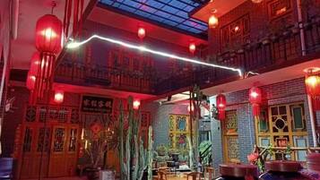 Un interior tradicional con techo alto, faroles rojos y un tragaluz.