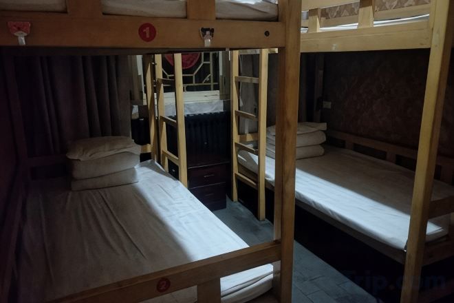Habitación con literas, una mesita y una cortina.