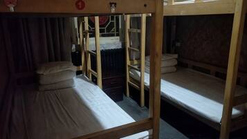 Habitación con literas, una mesita y una cortina.