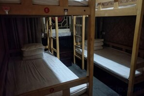 A bunk bed room with a ladder, a small table, and a curtain. - Pingyao Jiaxin Guesthouse (Pingyao County)