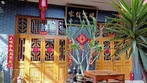 Ein traditionelles chinesisches Gebäude mit aufwendig geschnitzten Holztüren und einem Schild.