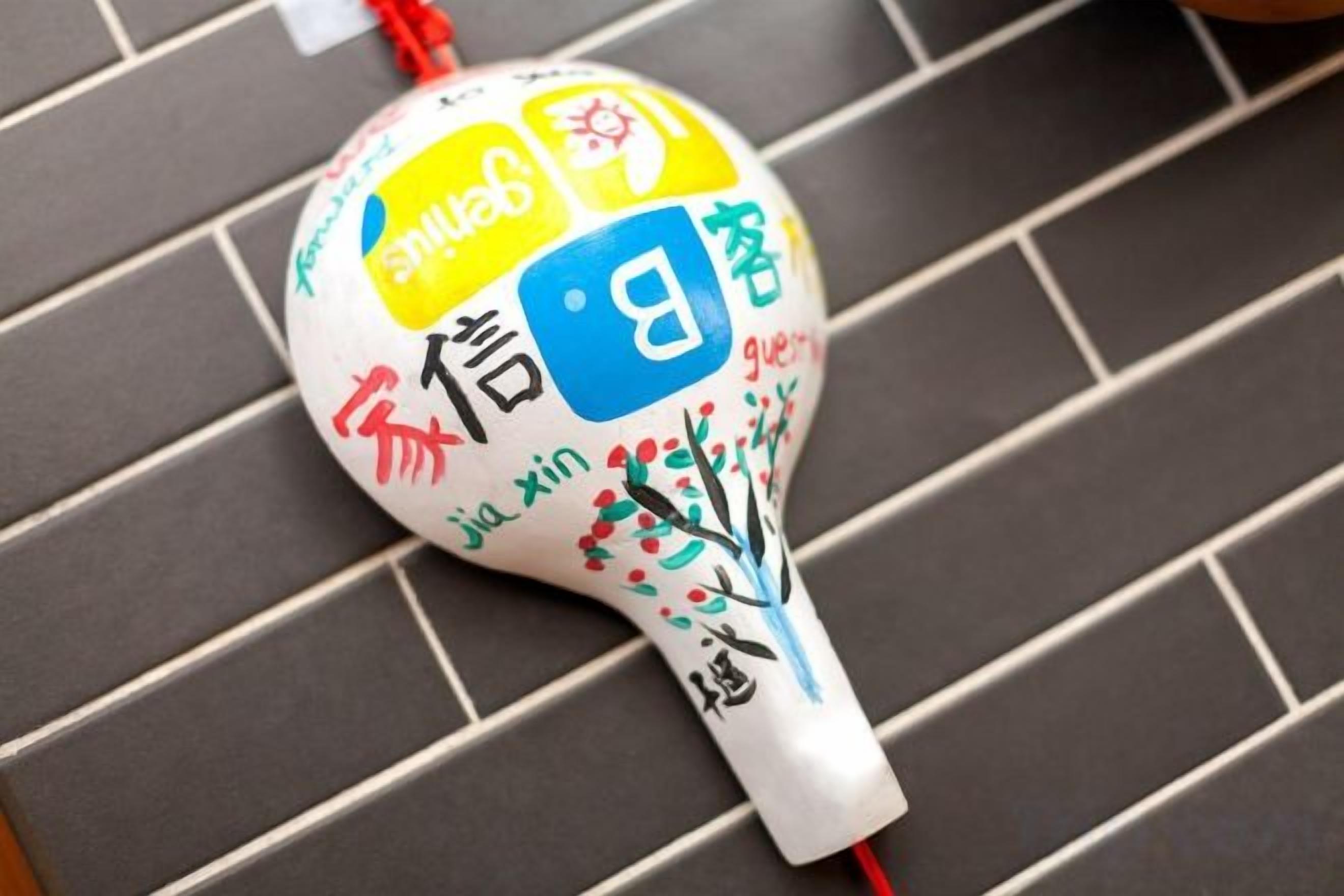 A white object with colorful text and symbols on a tiled surface.