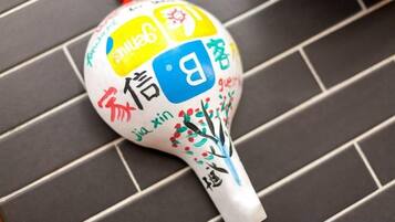A white object with colorful text and symbols on a tiled surface.
