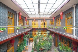 A traditional building with multiple balconies, indoor plants, and a central courtyard. - Pingyao Jiaxin Guesthouse (Pingyao County)